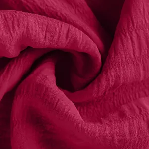 Macro detail view of dark pink crinkle fabric texture for summer fashion women's shorts.