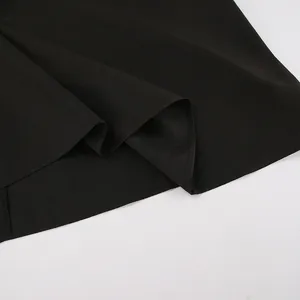 Detailed close-up showing the hem and fabric texture of a vintage black knit dress