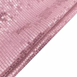 Close-up detail of shimmering pink sequined fabric texture for women's short jacket.