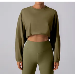 Close-up of olive green cropped long sleeve yoga top and high-waisted leggings set.
