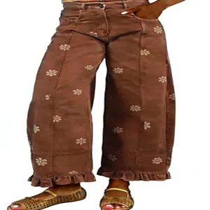 Detail of vintage Y2K wide-leg denim pants with floral daisy prints and ruffle hem