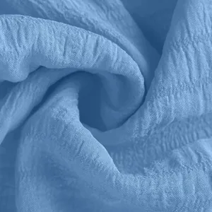 Macro view showing the breathable crinkle texture of the light blue sports shorts fabric