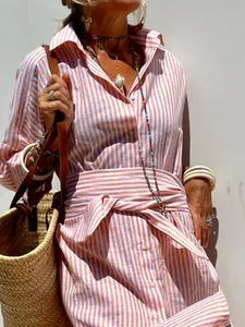 Detail shot of a stylish orange and white striped shirt dress with tie waist detail