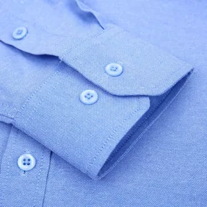 Ripresa macro dettagliata del polsino di una camicia Oxford da uomo azzurra