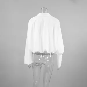Rückansicht weiße bauchfreie Polo-Bluse mit drapiertem Saum und Manschetten.
