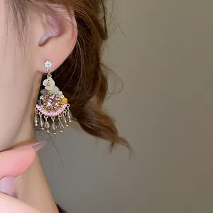 Detailed close-up of a bohemian crystal tassel earring worn on a model's ear.