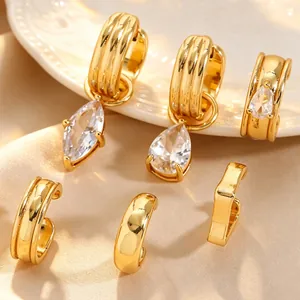 Vue détaillée de boucles d'oreilles dorées avec zircon marquise et bagues d'oreille épurées