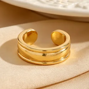 Gros plan détaillé d'un ear cuff doré minimaliste aux bords texturés sur un tissu en soie