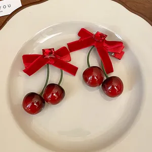 Detaillierte Makroansicht einer roten Haarspange mit Schleife und Kirsch-Anhängern