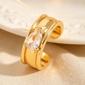 Gros plan d'un ear cuff doré orné d'une pierre en zircon en forme de larme étincelante