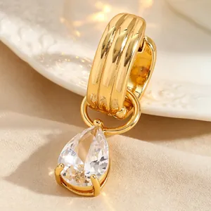 Gros plan sur une bague d'oreille dorée avec pendentif en zircon en forme de poire