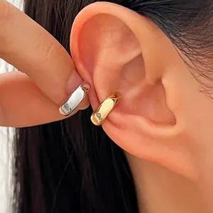 Gros plan de manchettes d'oreilles polies en or et argent avec petit zircon incrusté