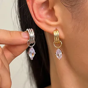 Gros plan de boucles d'oreilles élégantes en or et argent avec des pendentifs en zircon marquise.