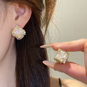 Vue détaillée de boucles d'oreilles géométriques en forme de losange avec cadre doré