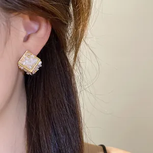 Gros plan détaillé d'une boucle d'oreille géométrique dorée avec incrustation