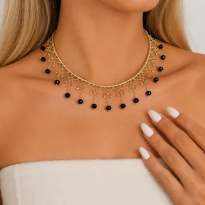 Nahaufnahme eines goldenen Vintage-Lace-Chokers mit schwarzen Perlenfransen.