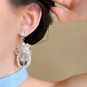 Eleganti orecchini pendenti in argento con grande zircone e grappolo di perle lucenti