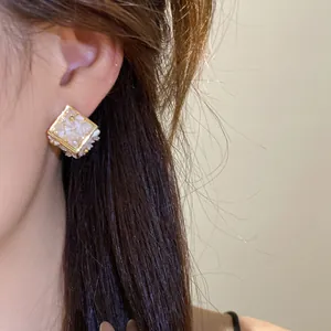 Gros plan détaillé de boucles d'oreilles géométriques en losange avec incrustation de pierre
