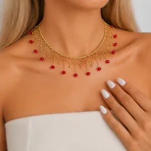 Detaillierte Ansicht eines Vintage-Gold-Chokers mit roten Glasperlen und Fransen.