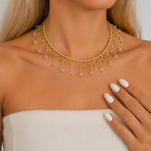 Nahaufnahme eines goldenen Vintage-Chokers mit Spitzenmuster und Glasperlen-Fransen