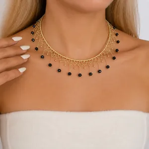 Nahaufnahme des filigranen Gold-Mesh-Musters und der schwarzen Glasperlen an diesem Choker