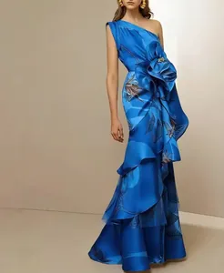 Detail view of elegant royal blue one-shoulder evening gown with large 3D flower accent