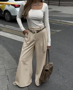 Streetstyle-Foto einer Frau in khakifarbenen weiten Hosen und weißem Langarmshirt