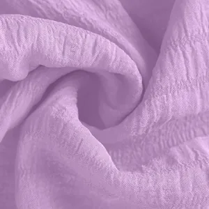 Detailed macro view of the light purple crinkled seersucker fabric texture for summer shorts