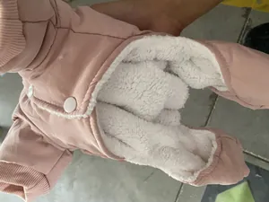 Close-up of pink dog winter coat with thick white fleece lining and snap buttons