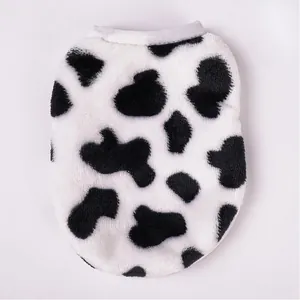 Vista dettagliata della morbida trama in peluche con stampa mucca su gilet per animali.