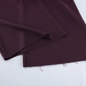 Detalle de primer plano de pantalones deportivos morados con dobladillo sin rematar y tela.