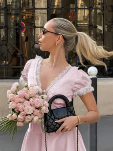Detailed view of pink French style lace dress with deep V-neck and puff sleeves