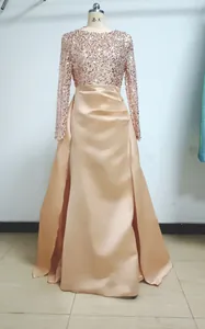Elegant rose gold evening gown with sequined long sleeves and draped satin skirt