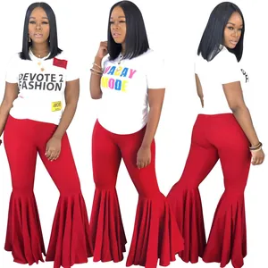 Detalle de pantalón acampanado rojo con volante plisado y camiseta con letras
