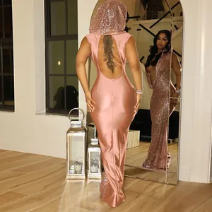 Détail d'une robe longue à paillettes rose avec capuche et un design élégant dos nu.