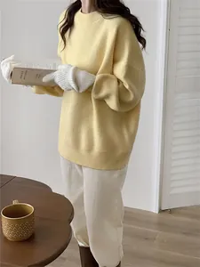 Détail d'un pull-over en maille jaune doux de style vintage avec des poignets côtelés