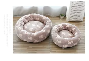 Detail view of two plush round pet beds with cute teddy bear pattern for cats and dogs