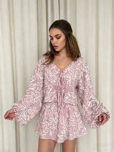 Vista dettagliata del set vacanze in jacquard rosa con ricami floreali e lacci
