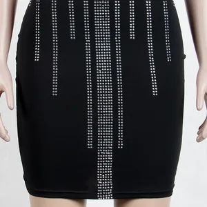 Detailed macro view of black mini dress featuring vertical sparkling rhinestone embellishments