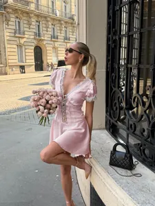 Elegant pink lace V-neck dress with bubble sleeves shown in a Parisian street scene