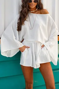 Detailed shot of white two-piece set featuring a loose long-sleeve top and shorts.
