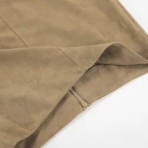 Nahaufnahme des verdeckten Reißverschlusses am khakifarbenen Wildleder-Midirock mit Textur