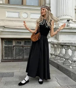 Elegant model posing in a retro black sleeveless Hepburn style midi dress outdoors