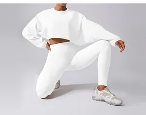 Woman in white cropped sports sweatshirt and leggings set for yoga and fitness