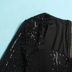Detail view of a black sequined bodycon dress showing fabric texture and gold zipper
