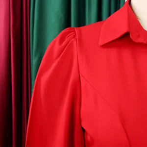 Detalle de cerca de un vestido rojo con mangas abullonadas y diseño de cuello camisero