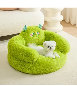 Close-up of green plush monster dog bed featuring cute embroidered face and horns