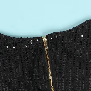 Close-up macro detail of the high-quality gold zipper on a black sequined sexy bodycon dress