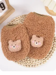 Dettaglio di un pesante gilet in pile marrone per animali con patch a testa di orso