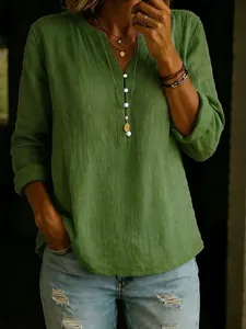 Detail shot of green linen v-neck blouse with buttons and relaxed fit styling